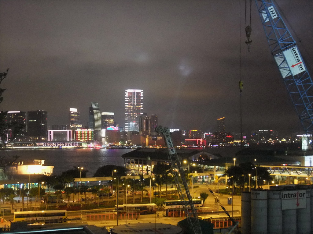 Victoria Harbour with the Star Ferry Pier and the skyline of Kowloon during the `A Symphony of Lights` multimedia show, viewed from the roof terrace of the IFC Mall, by night