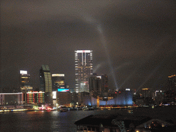 Victoria Harbour with the Star Ferry Pier and the skyline of Kowloon during the `A Symphony of Lights` multimedia show, viewed from the roof terrace of the IFC Mall, by night