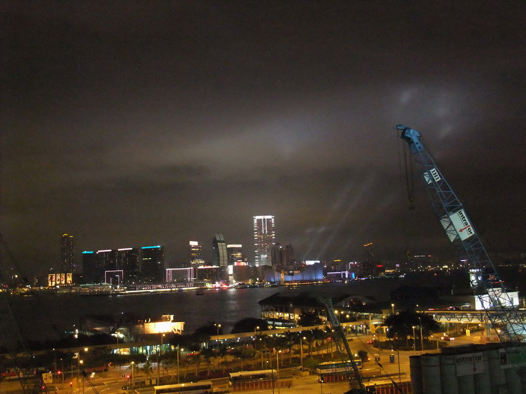 Victoria Harbour with Central Ferry Pier 6, 7 and 8, and the skyline of Kowloon during the `A Symphony of Lights` multimedia show, viewed from the roof terrace of the IFC Mall, by night