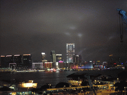 Victoria Harbour with the Star Ferry Pier and the skyline of Kowloon during the `A Symphony of Lights` multimedia show, viewed from the roof terrace of the IFC Mall, by night
