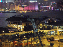 The Star Ferry Pier, Victoria Harbour, the Hong Kong Cultural Centre and the Clock Tower during the `A Symphony of Lights` multimedia show, viewed from the roof terrace of the IFC Mall, by night