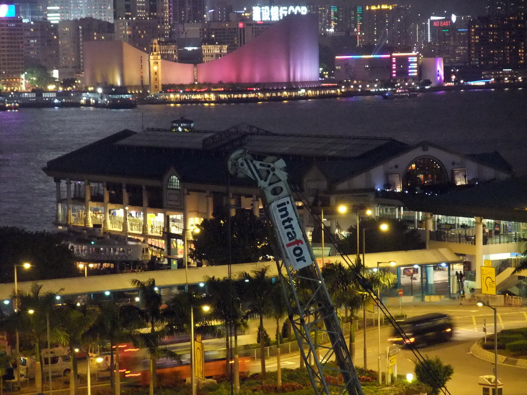 The Star Ferry Pier, Victoria Harbour, the Hong Kong Cultural Centre and the Clock Tower during the `A Symphony of Lights` multimedia show, viewed from the roof terrace of the IFC Mall, by night