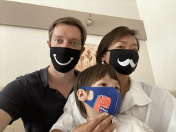 Tim, Miaomiao and Max wearing facial masks in our room at the Vayamundo Houffalize hotel