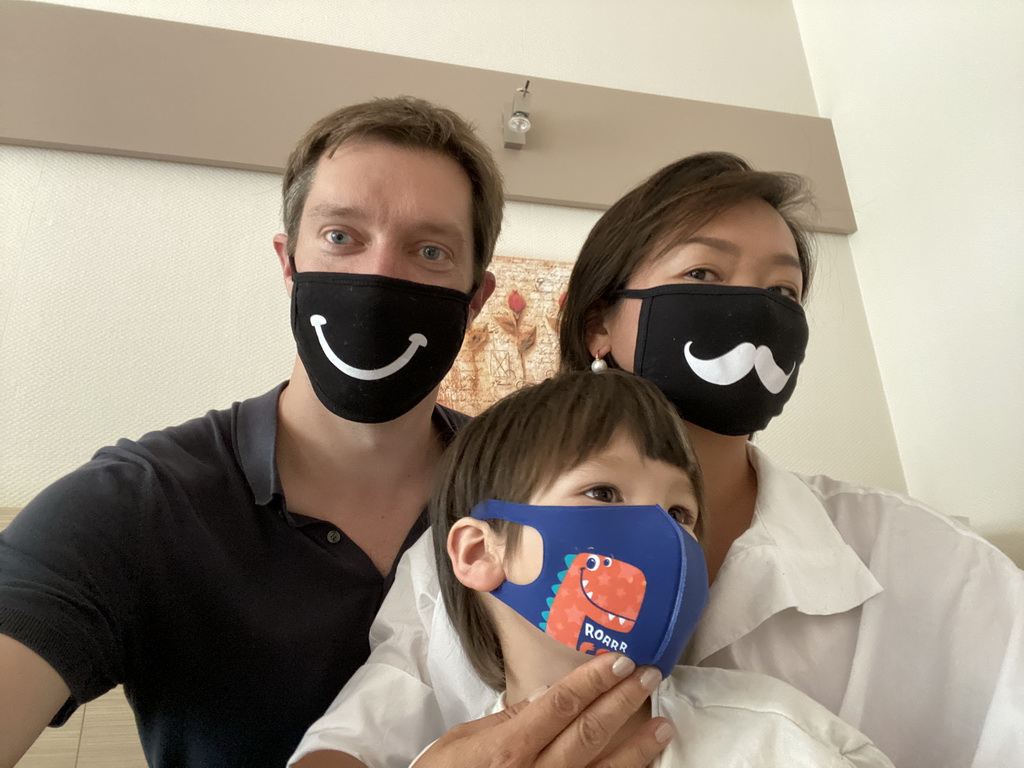 Tim, Miaomiao and Max wearing facial masks in our room at the Vayamundo Houffalize hotel