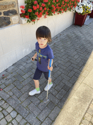 Max with minigolf sticks at the Place de l`Église square