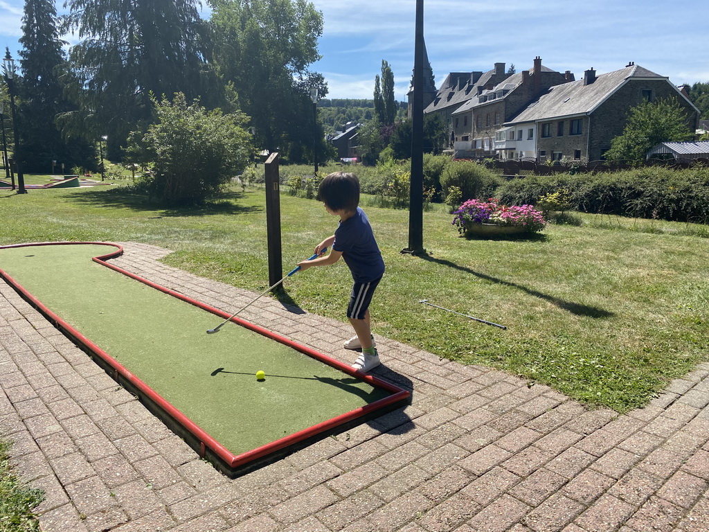 Max playing minigolf at the minigolf court at the northeast side of the town, with a view on the Église Sainte-Catherine church