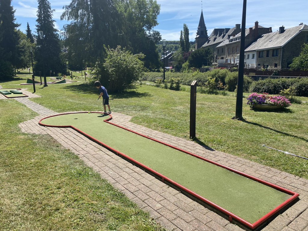 Max playing minigolf at the minigolf court at the northeast side of the town, with a view on the Église Sainte-Catherine church