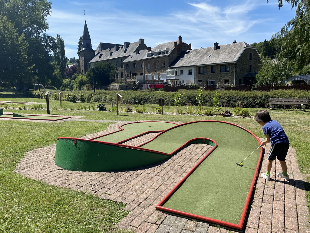 Max playing minigolf at the minigolf court at the northeast side of the town, with a view on the Église Sainte-Catherine church