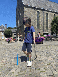 Max with minigolf sticks in front of the Église Sainte-Catherine church at the Place de l`Église square