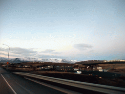 The Suðurlandsvegur road and mountains and buildings at the east side of Reykjavik, viewed from the rental car