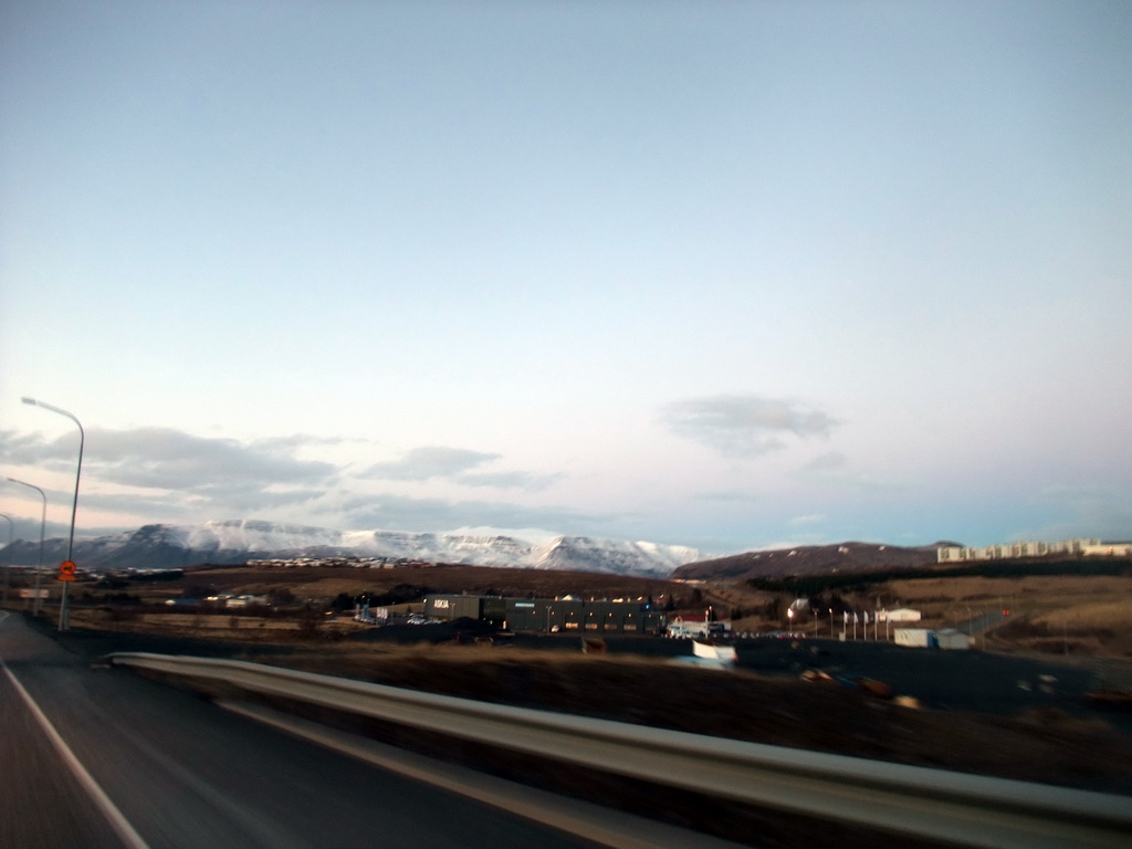 The Suðurlandsvegur road and mountains and buildings at the east side of Reykjavik, viewed from the rental car