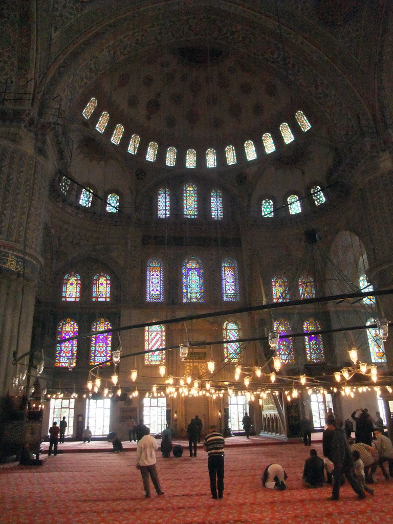 Praying muslims and interior of the Blue Mosque