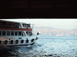 Boat under the Galata Bridge over the Golden Horn bay