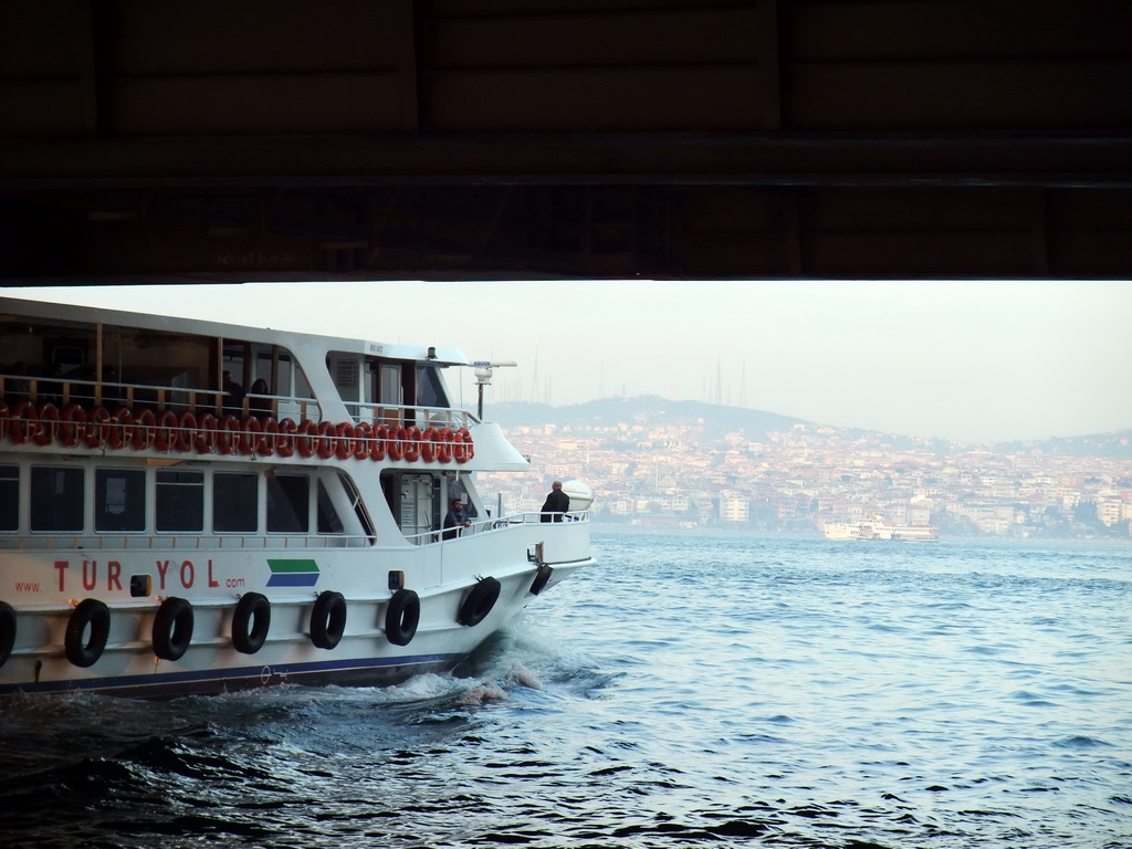 Boat under the Galata Bridge over the Golden Horn bay