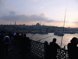 Fishermen on the Galata Bridge, with a view over boats in the Golden Horn, the Rüstem Pasha Mosque and the Süleymaniye Mosque