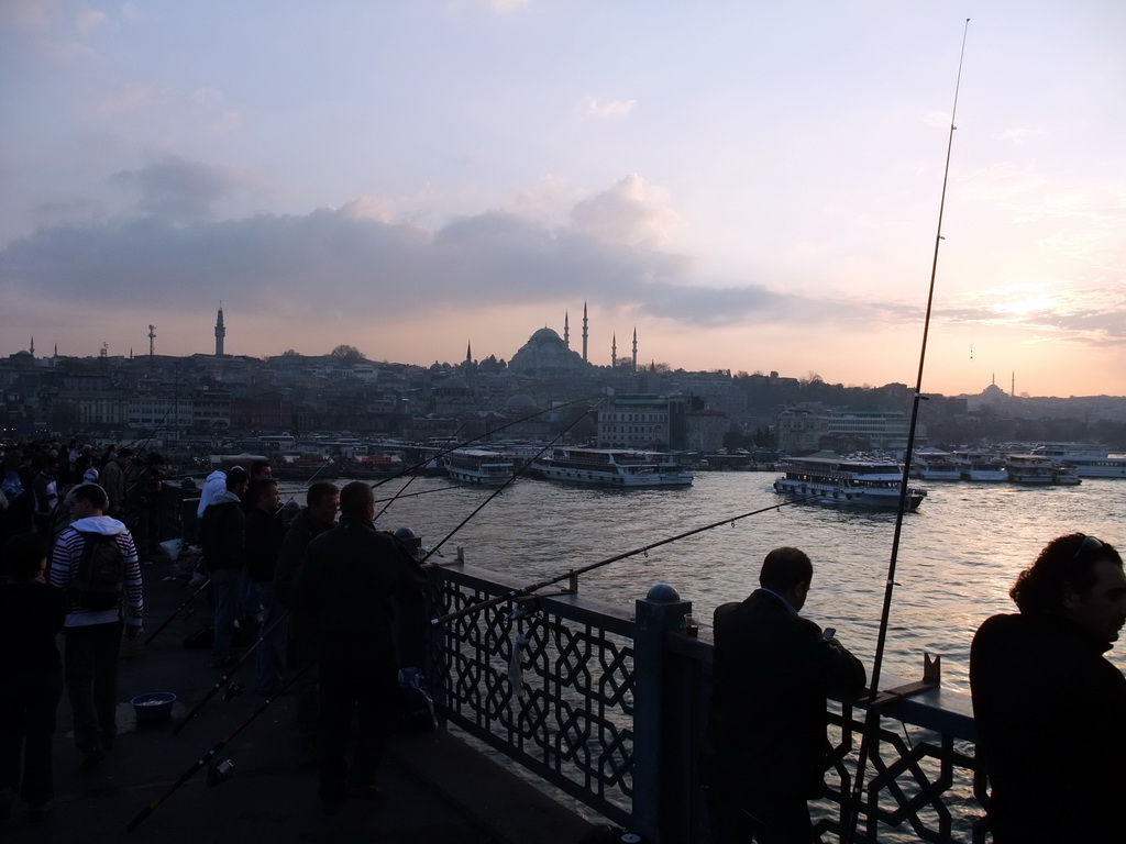 Fishermen on the Galata Bridge, with a view over boats in the Golden Horn, the Rüstem Pasha Mosque and the Süleymaniye Mosque