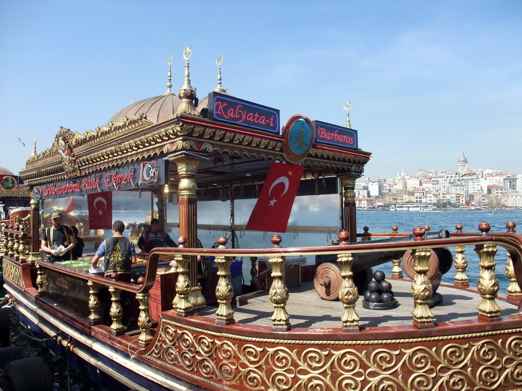 Fish boat restaurant in the Golden Horn bay, and the Galata Tower in the Beyoglu district