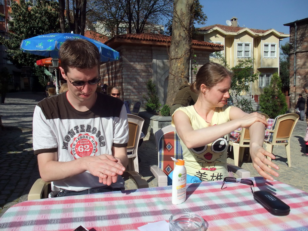 Tim and Nardy putting on sunscreen, on the square in front of the Church of St. Savior in Chora