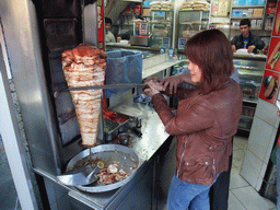 Miaomiao and the cook cutting doner kebab in a snackbar at Divan Yolu Caddesi street