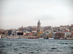 The Beyoglu district with the Galata Tower and a boat in the Bosphorus strait, viewed from the ferry