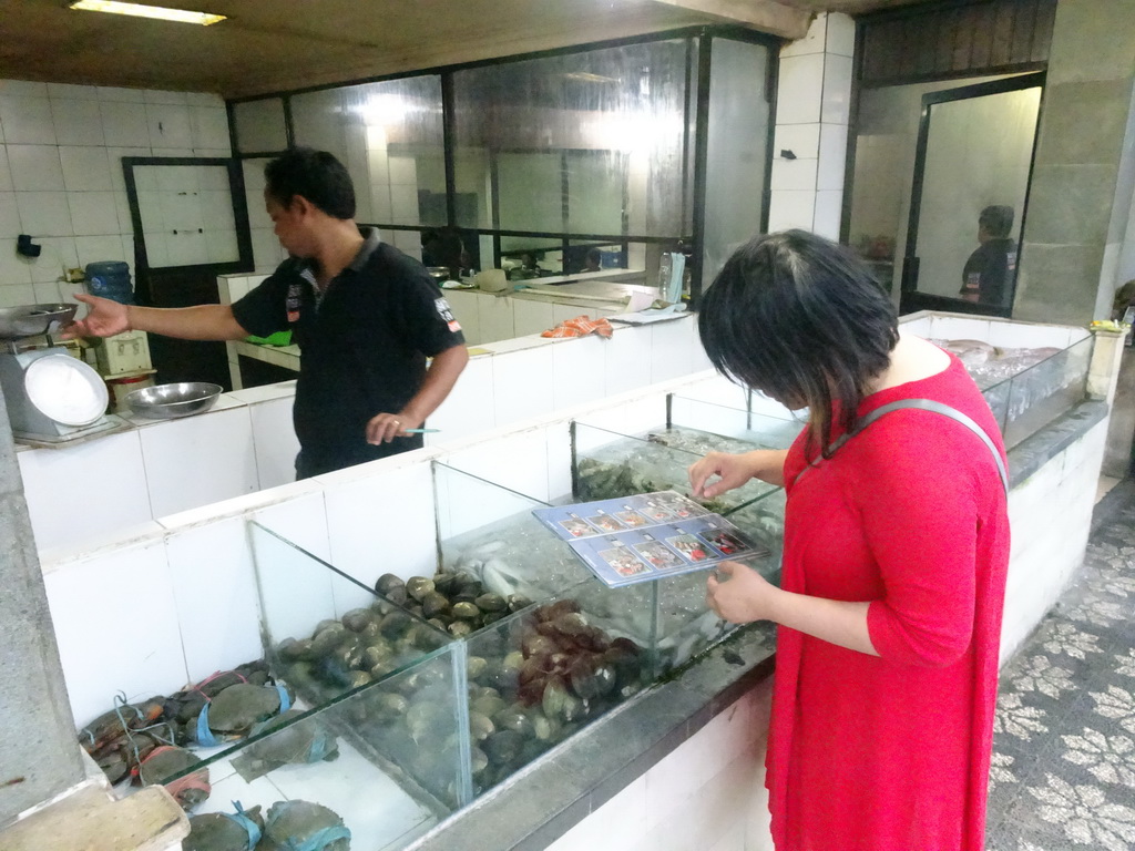 Miaomiao picking food at the back side of the Teba Café restaurant at Jimbaran Beach