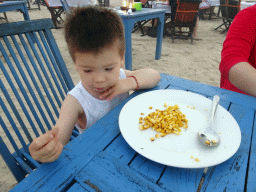 Max eating corn at the terrace of the Teba Café restaurant at Jimbaran Beach, at sunset