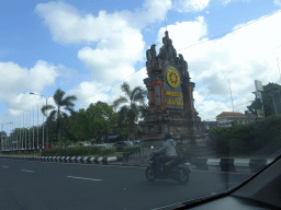 Entrance sign of Udayana University at the Jalan Raya Kampus Unud street, viewed from the taxi