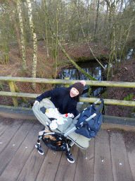 Miaomiao with Max in a trolley on a bridge over a river at the Center Parcs Kempervennen holiday park