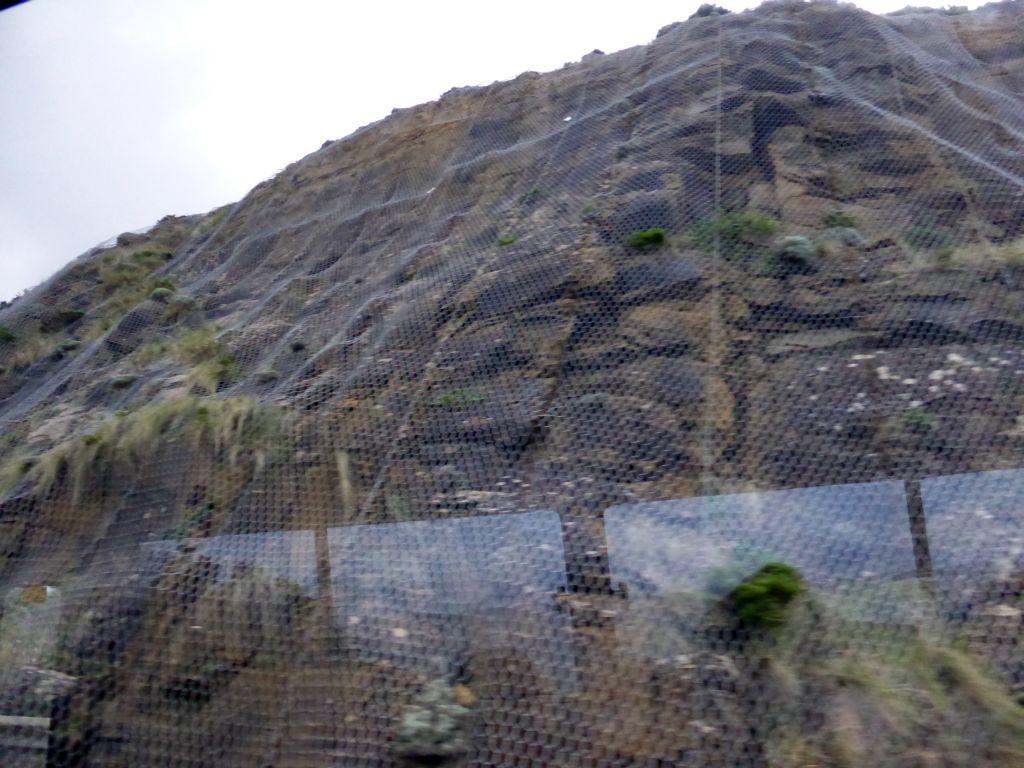 Rocks kept together by a net near Cape Patton, viewed from our tour bus on the Great Ocean Road