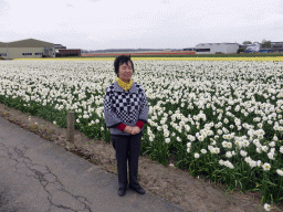 Miaomiao`s mother with white, yellow and red flowers at flower fields at the south side of the Zilkerbinnenweg street at the village of De Zilk