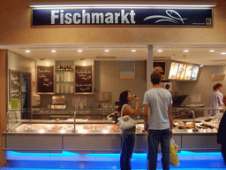 Tim and Miaomiao in the fish department in a supermarket