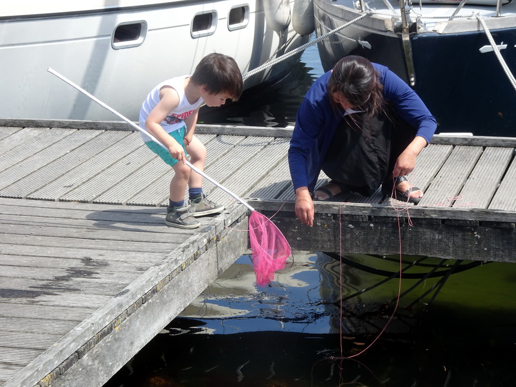 Max and a friend catching crabs on a pier at Camping and Villa Park De Paardekreek