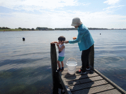 Max and Miaomiao`s mother catching crabs on a pier at Camping and Villa Park De Paardekreek