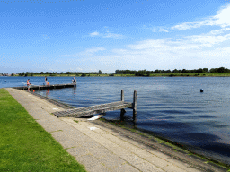 Pier with people catching crabs at Camping and Villa Park De Paardekreek