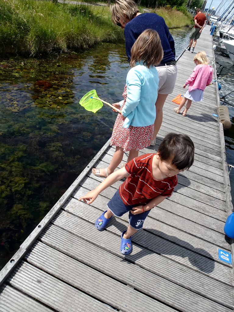 Max catching crabs on a pier at Camping and Villa Park De Paardekreek