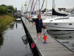 Miaomiao and Max catching crabs on a pier at Camping and Villa Park De Paardekreek