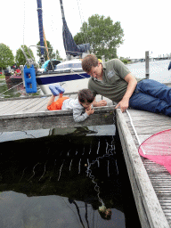 Tim and Max catching crabs on a pier at Camping and Villa Park De Paardekreek