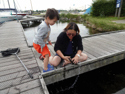 Miaomiao and Max catching crabs on a pier at Camping and Villa Park De Paardekreek