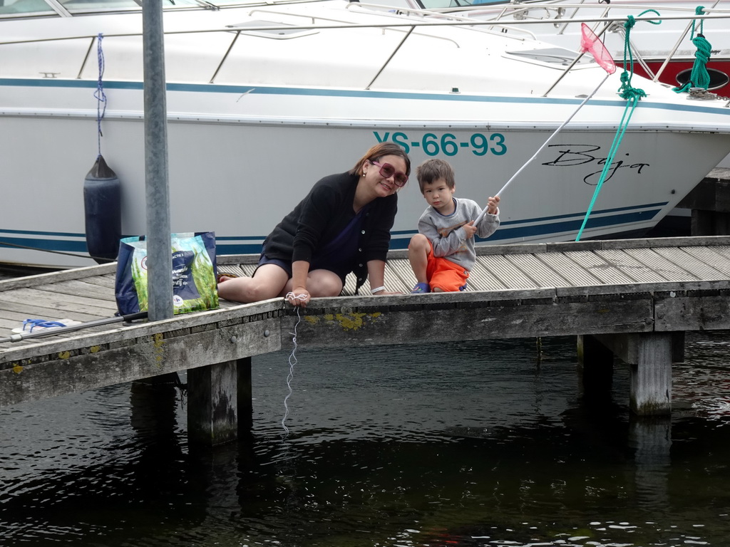 Miaomiao and Max catching crabs on a pier at Camping and Villa Park De Paardekreek