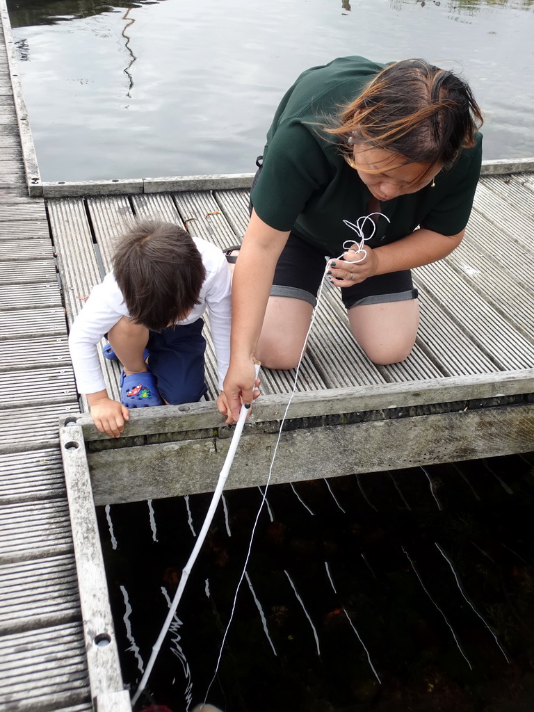 Miaomiao and Max catching crabs on a pier at Camping and Villa Park De Paardekreek