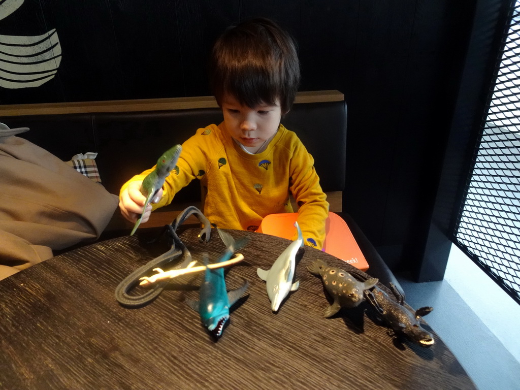 Max playing with dinosaur and animal toys at the Departure Hall of Eindhoven Airport