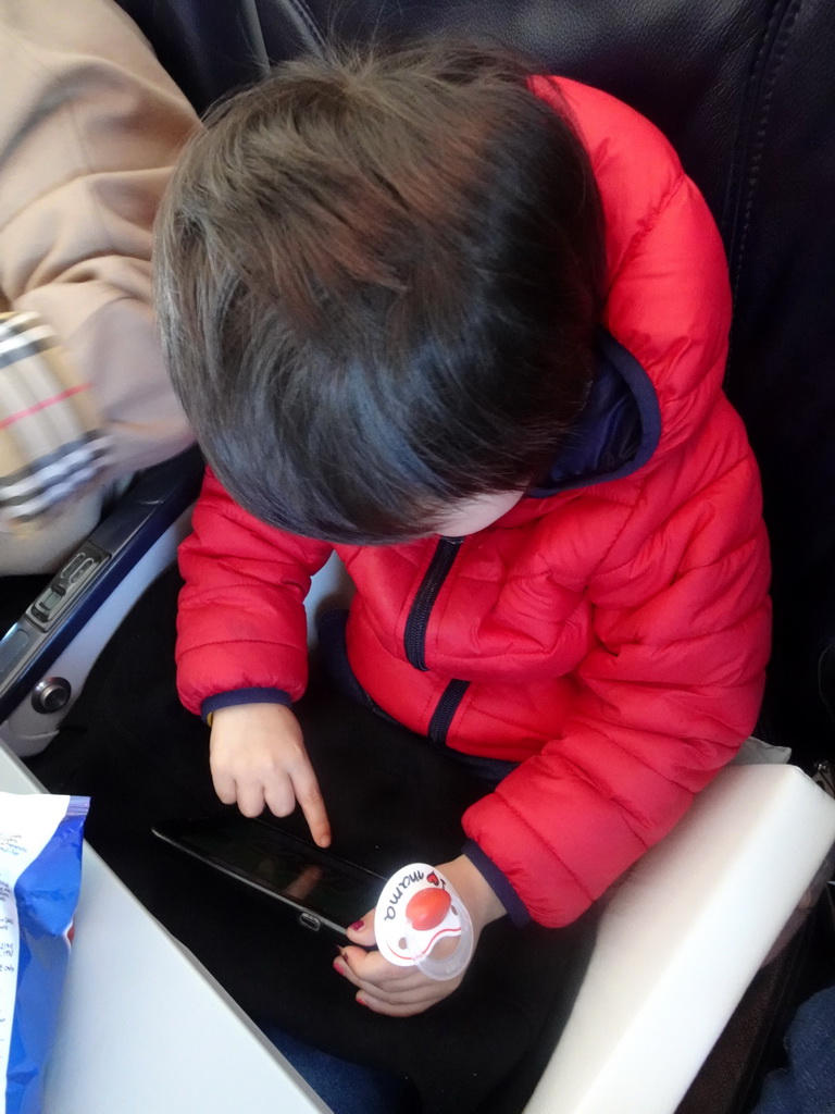 Max playing with iPhone in the airplane from Eindhoven