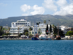 Boats and buildings at the southwest side of the Limenas Ko harbour and hills, viewed from the northwest side