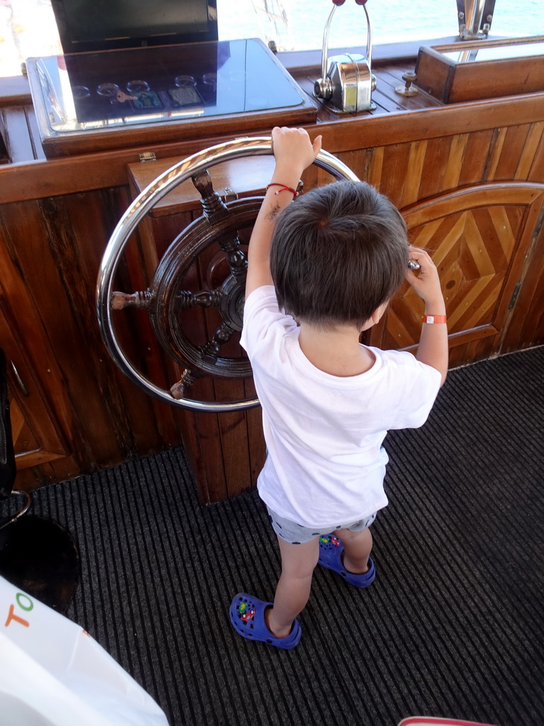 Max behind the helm of a tourist boat on the southwest side of the Limenas Ko harbour