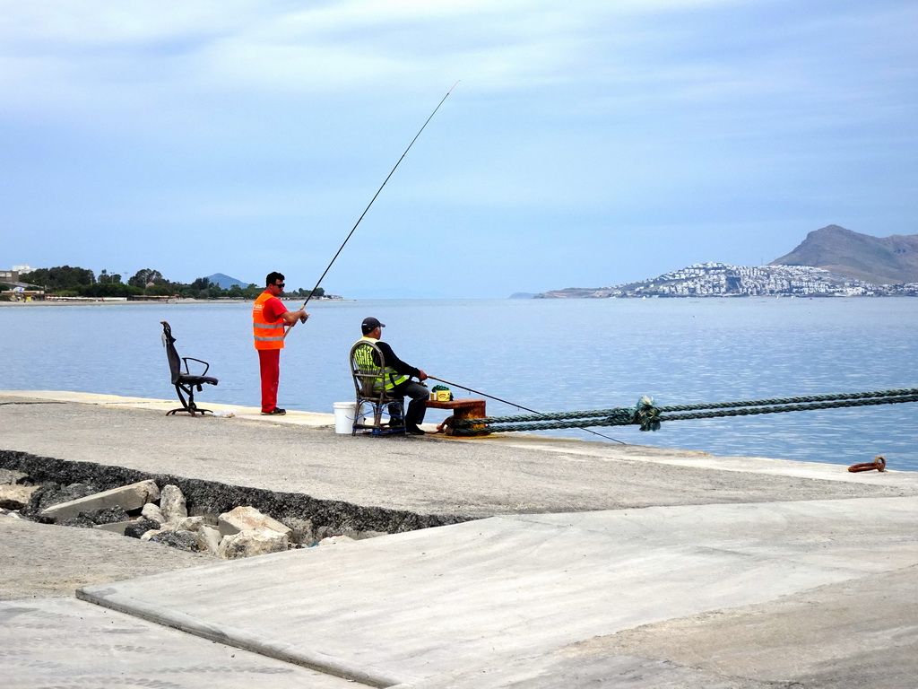 Fishermen at Kos Port, with a view on the Aegean Sea and the Bodrum Peninsula in Turkey