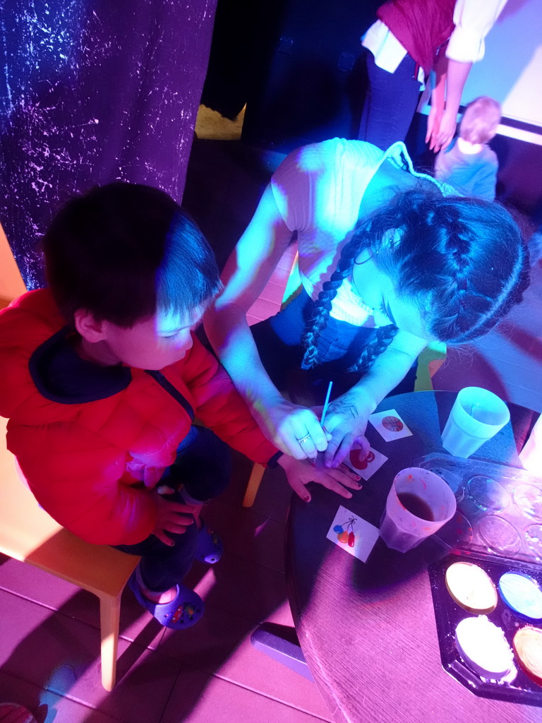 Max getting his hand painted at the Entertainment Tent at the Blue Lagoon Resort, by night