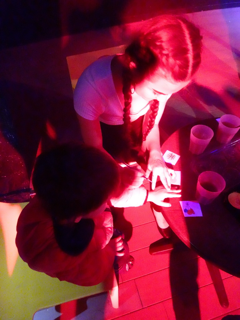 Max getting his hand painted at the Entertainment Tent at the Blue Lagoon Resort, by night