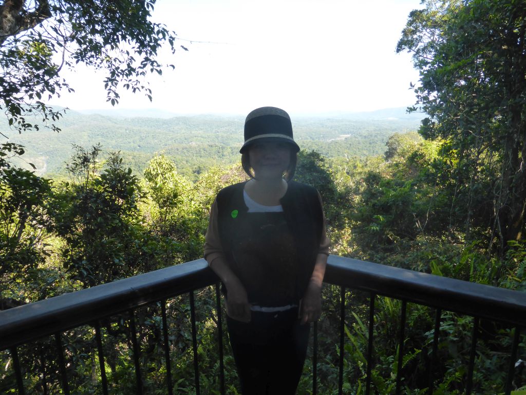 Miaomiao at the viewpoint at Red Peak Skyrail Station, with a view on the tropical rainforest