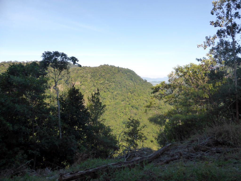 Hills with trees on the other side of the Barron Creek valley, viewed from the Kuranda Scenic Railway train near the Forwards Lookout