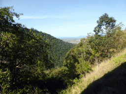 Hills with trees on the other side of the Barron Creek valley, viewed from the Kuranda Scenic Railway train near the Red Bluff rocks